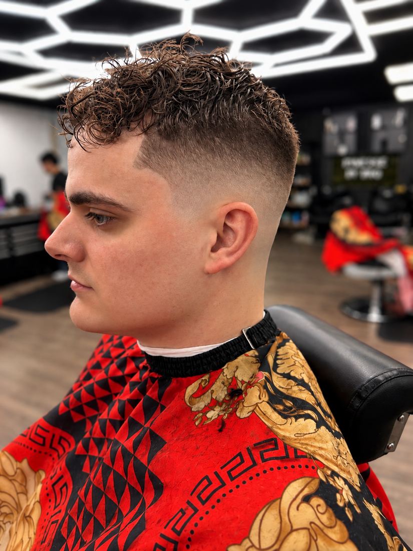 Curly top with a high fade at Finesse It Pro, a barbershop near Mango